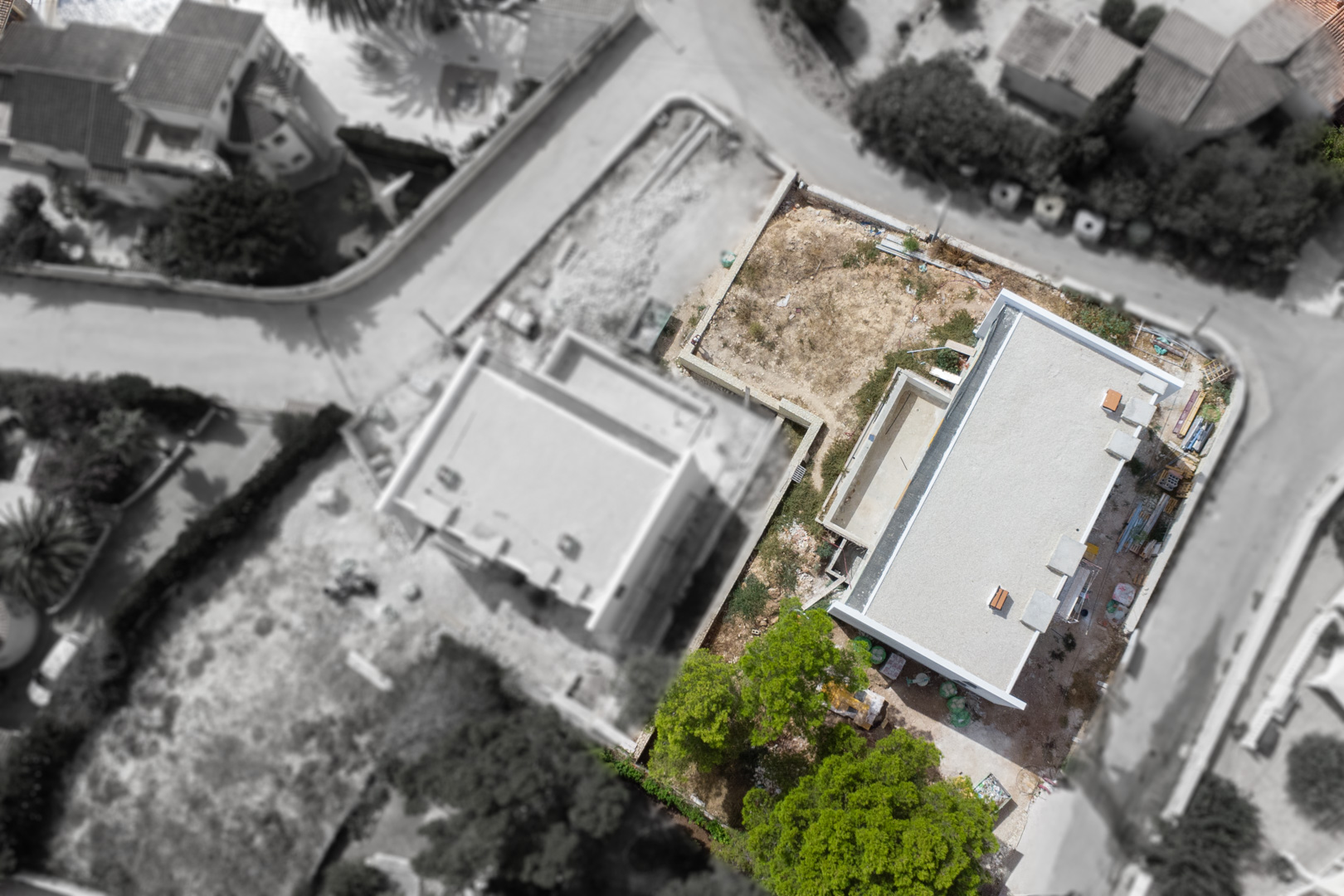 Vista aérea del progreso de construcción que muestra la estructura de la villa, la excavación de la piscina y la distribución de la parcela llana en Calpe.