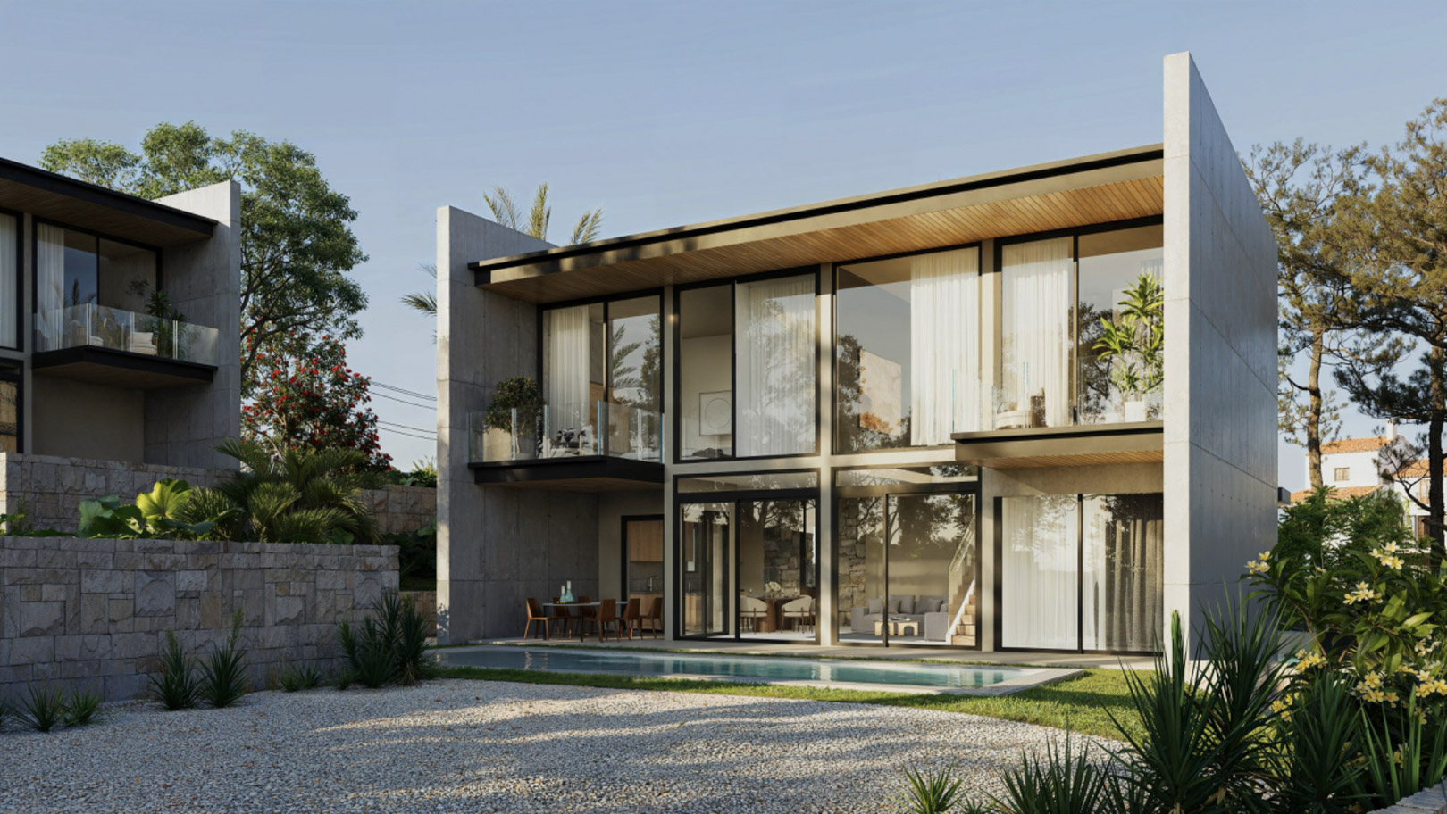 Fachada moderna de hormigón y cristal con amplios ventanales, terrazas privadas y una piscina rectangular rodeada de vegetación mediterránea y muros de piedra natural.