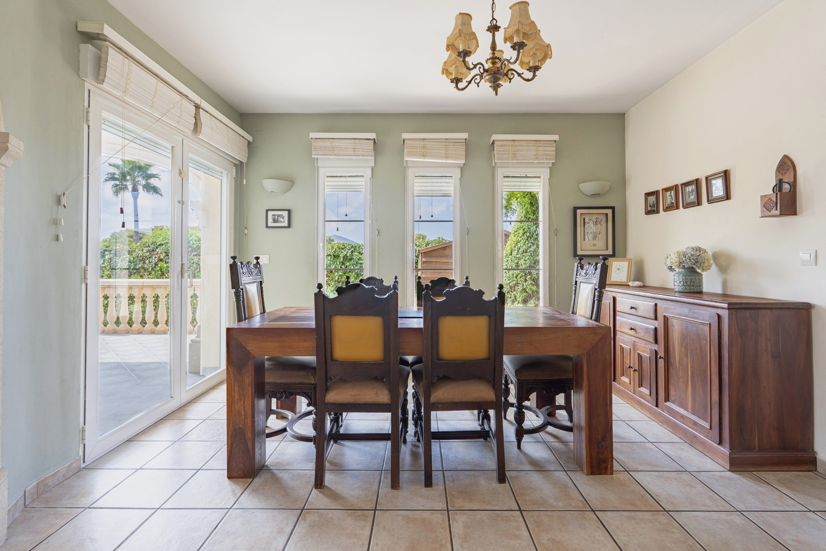 Comedor luminoso con mesa de madera maciza y aparador a juego. Acceso a terraza exterior.