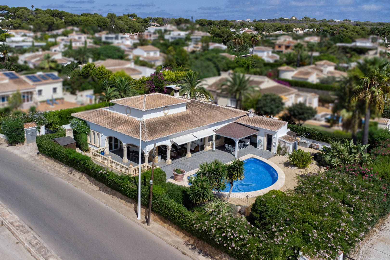 Vista aérea de villa con piscina privada, terraza cubierta y jardín maduro en Costa Nova, Jávea.