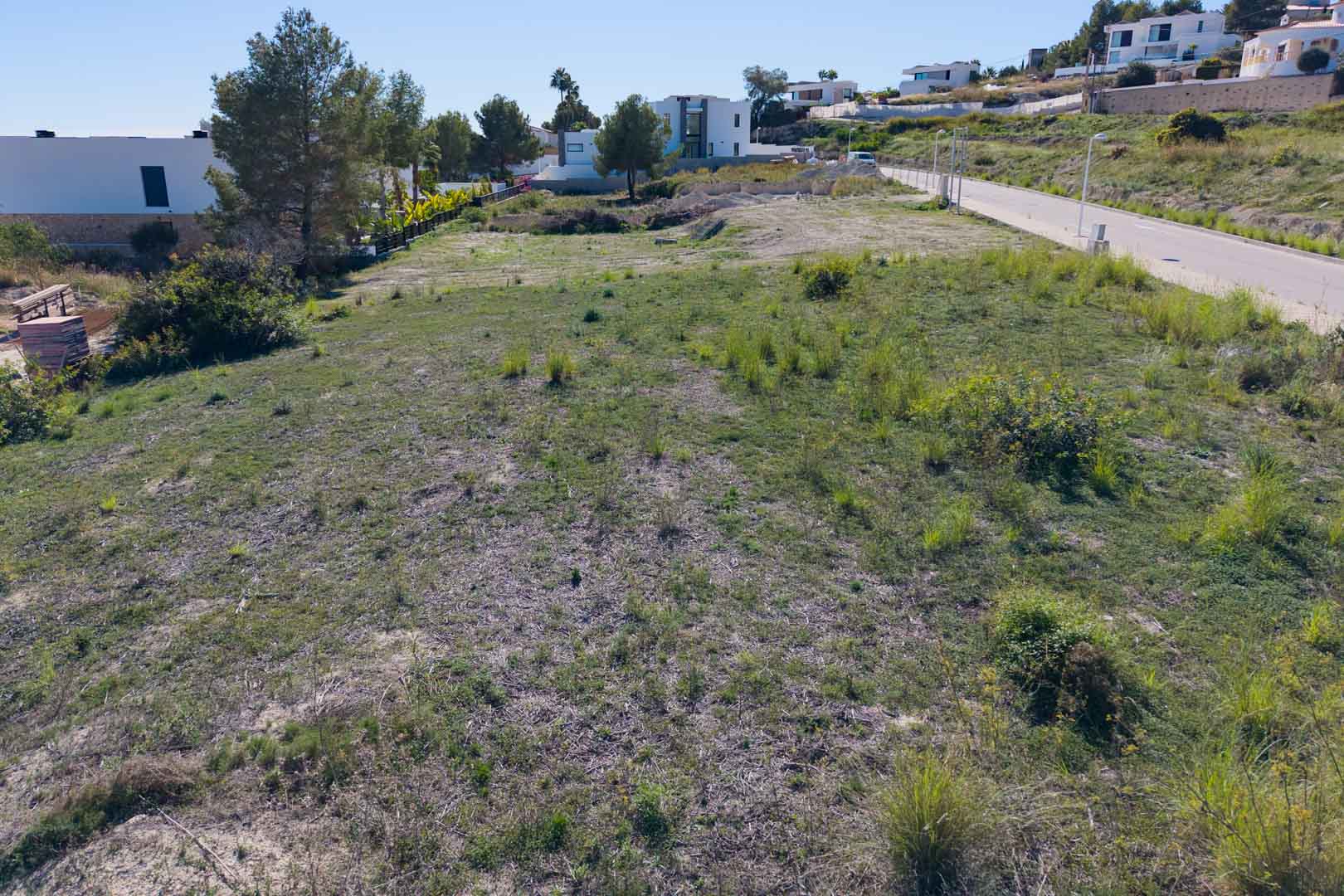 Parcela urbana llana en El Tesoro, Moraira, con acceso asfaltado y rodeada de villas modernas. Ofrece vistas despejadas al valle en un entorno residencial consolidado.