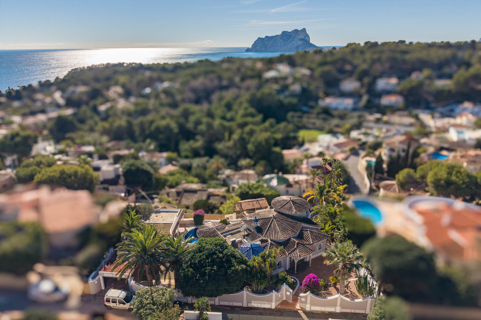 Vista aérea de la villa en Benissa con arquitectura de techos cónicos, rodeada de jardines mediterráneos y vistas panorámicas al mar y al Peñón de Ifach.