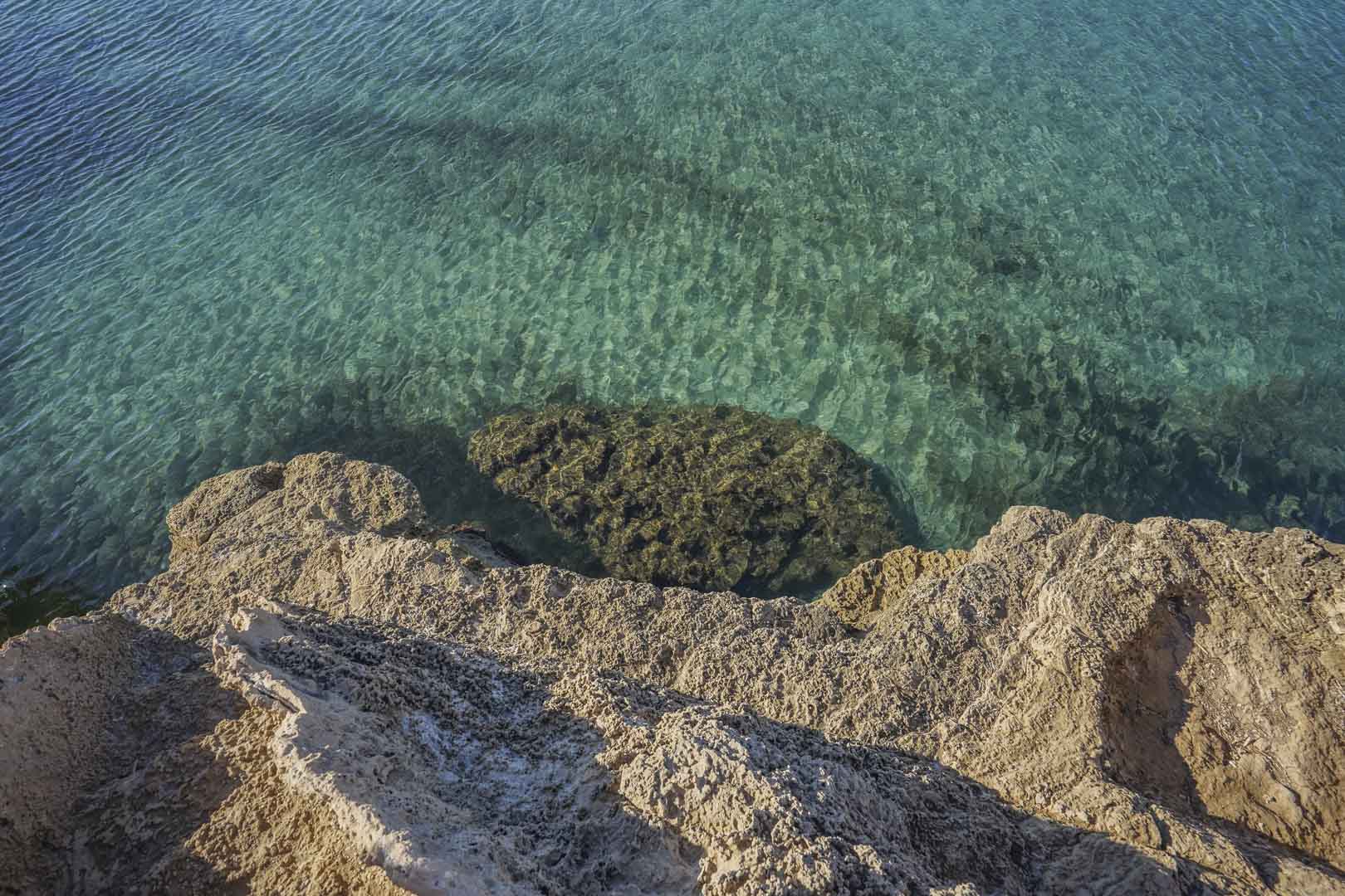 Vista detallada de las aguas cristalinas y la costa rocosa mediterránea cerca de la propiedad, destacando la proximidad a las calas vírgenes de Jávea.