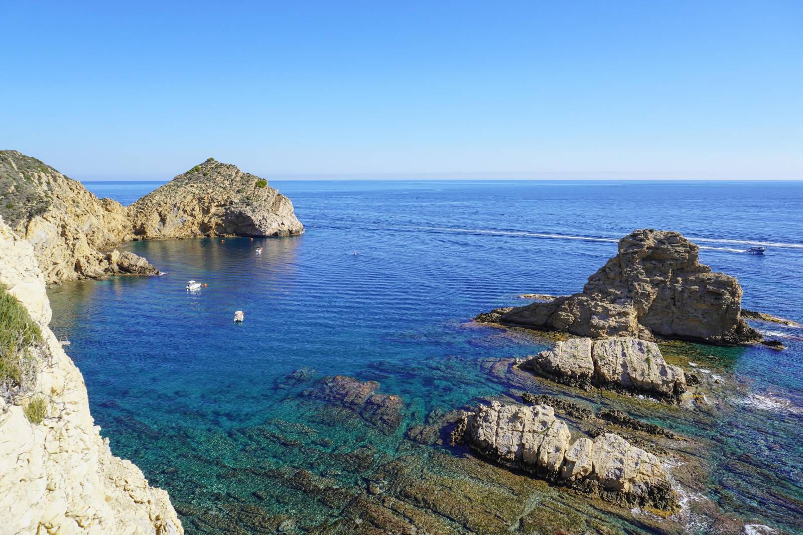 Vista panorámica de una cala con aguas turquesas y acantilados rocosos en Jávea, reflejando el entorno costero cercano a la propiedad.