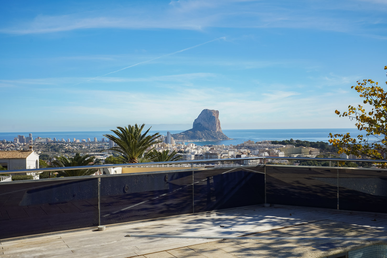 Terraza con barandilla de cristal y acero que ofrece vistas directas al Peñón de Ifach, el mar Mediterráneo y el núcleo urbano de Calpe.