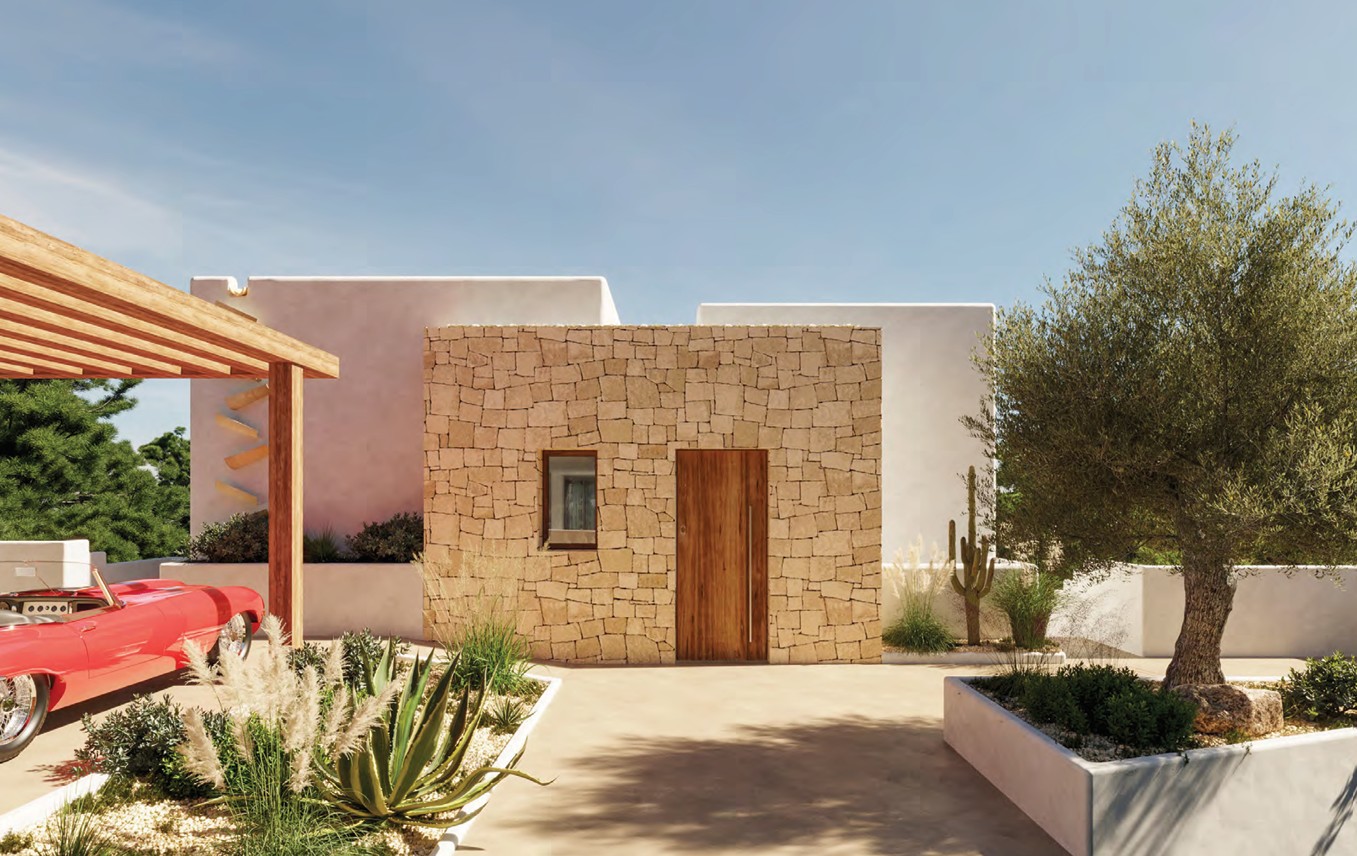 Fachada de piedra con puerta de madera y jardín mediterráneo con cactus y olivo.