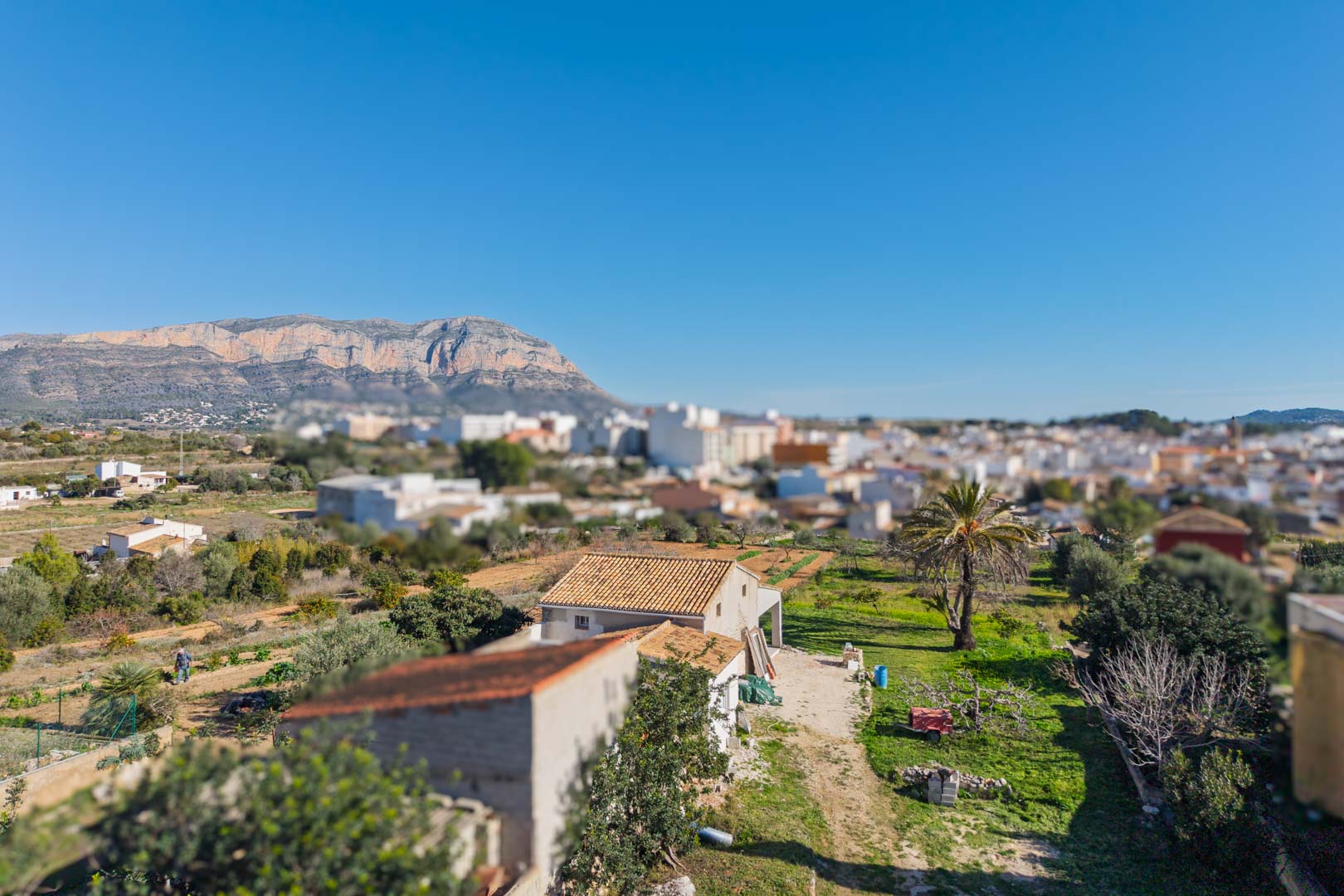 Vista panorámica de la finca con el macizo del Montgó al fondo, destacando la amplitud de la parcela y su cercanía al núcleo urbano de Gata de Gorgos.