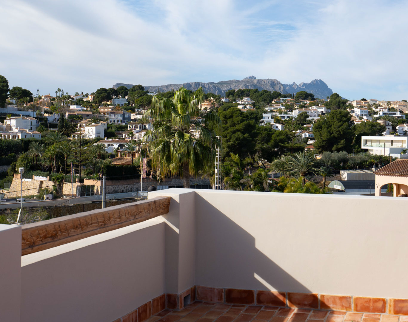 Azotea con suelos de terracota y vistas despejadas a la Sierra de Bernia y el entorno residencial de Benissa, rodeada de vegetación mediterránea.