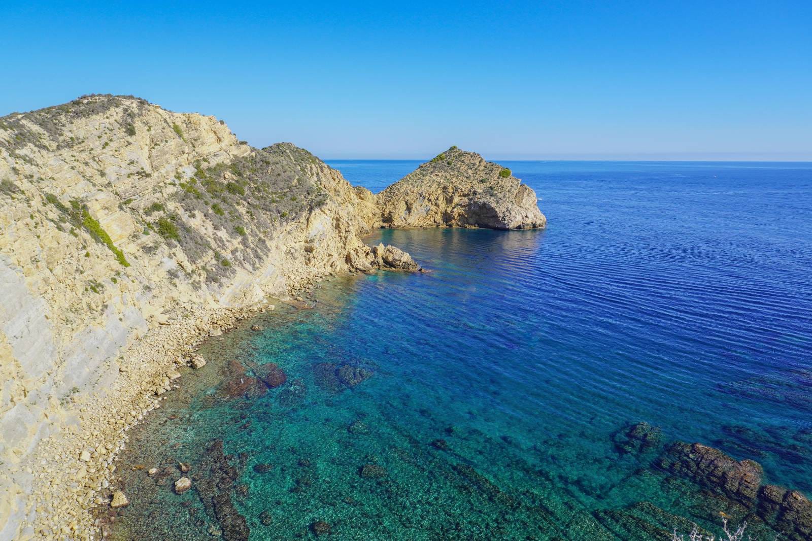 Vista panorámica de los acantilados de Jávea y aguas cristalinas de color turquesa, resaltando el entorno natural privilegiado cerca de la vivienda.