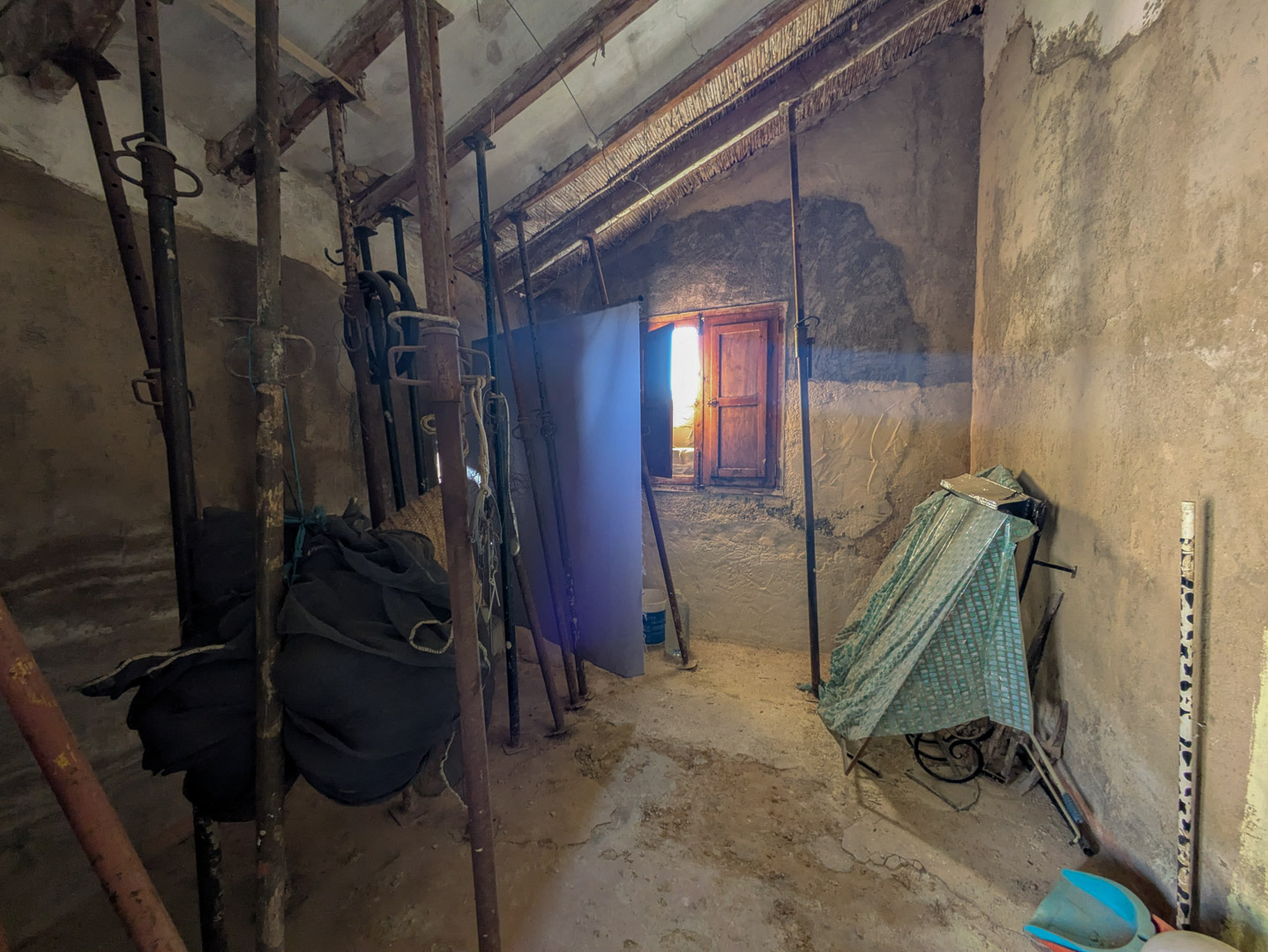 Interior de la finca con techos tradicionales de cañizo y vigas de madera, actualmente reforzados con puntales metálicos durante el proceso de reforma.