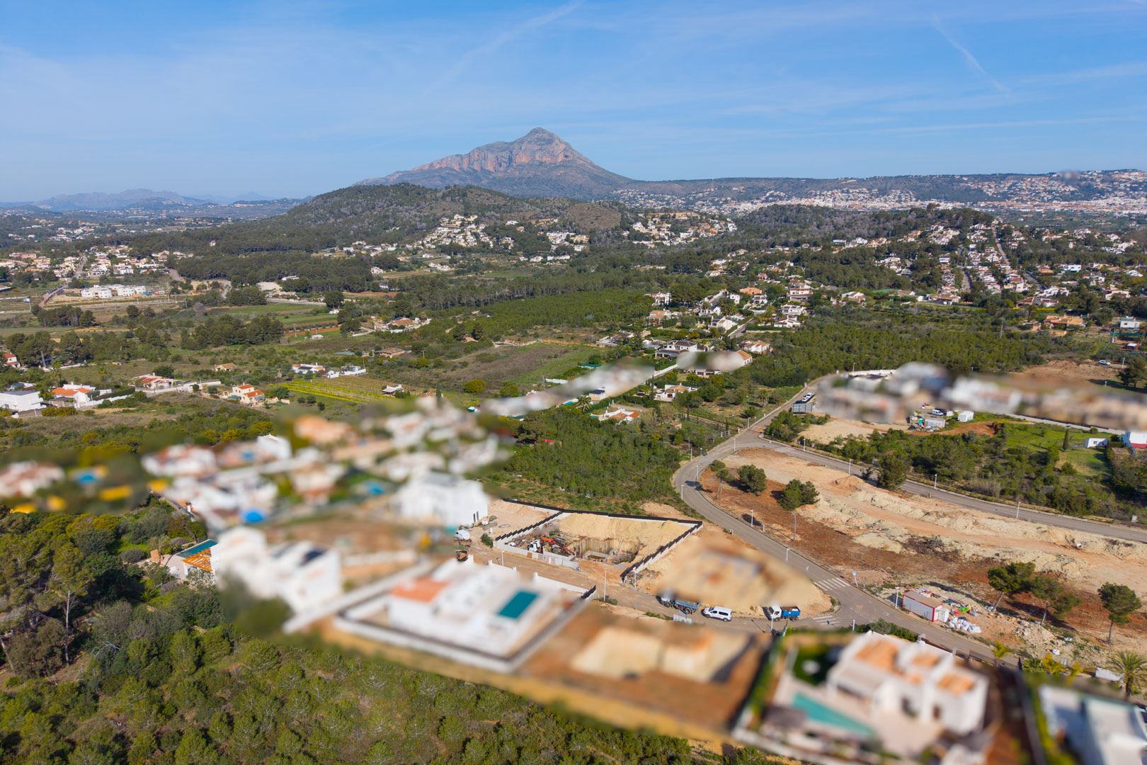 Vista aérea de la urbanización Valsol en Jávea, destacando el entorno natural y la emblemática montaña del Montgó al fondo bajo un cielo despejado.