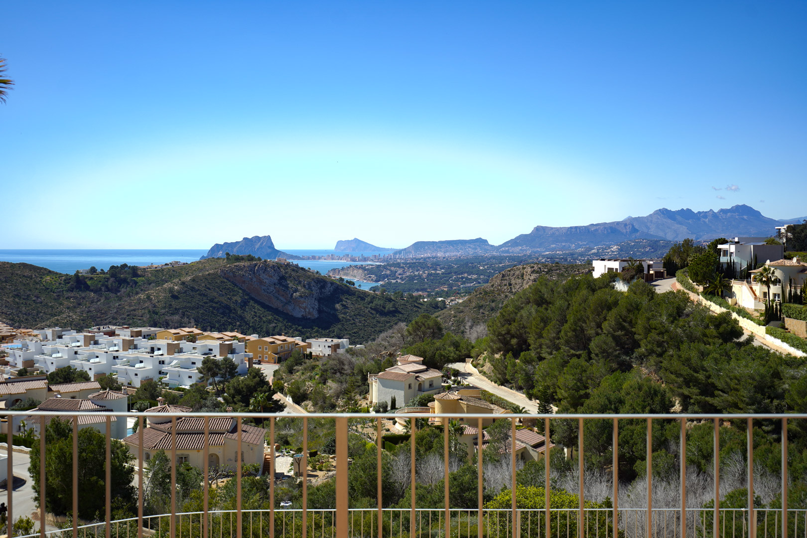 Vistas panorámicas desde la terraza hacia el Peñón de Ifach en Calpe y la costa de Benidorm, rodeadas de la vegetación mediterránea de Cumbre del Sol.