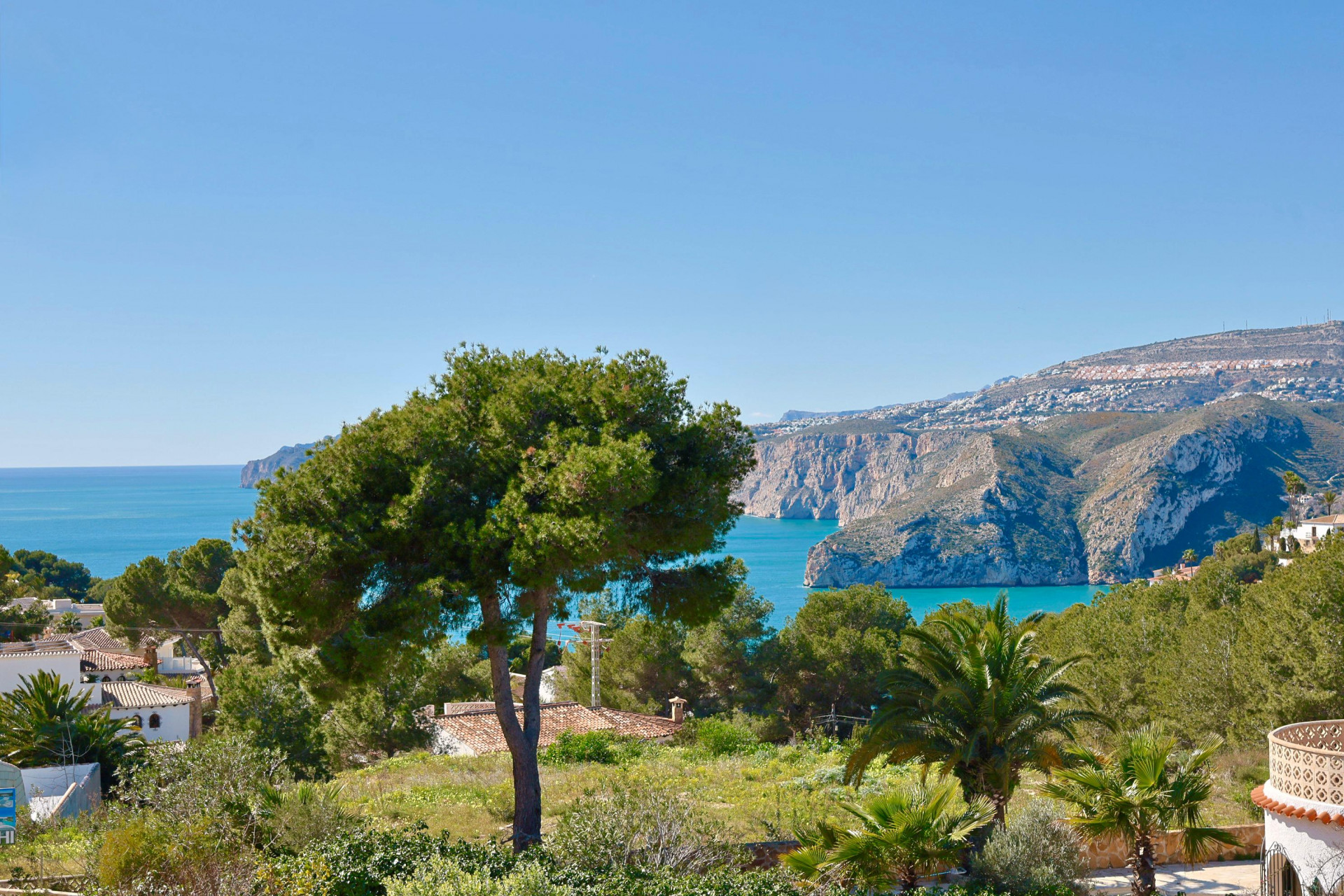 Vista panorámica de Jávea con vegetación exuberante y el mar Mediterráneo al fondo.