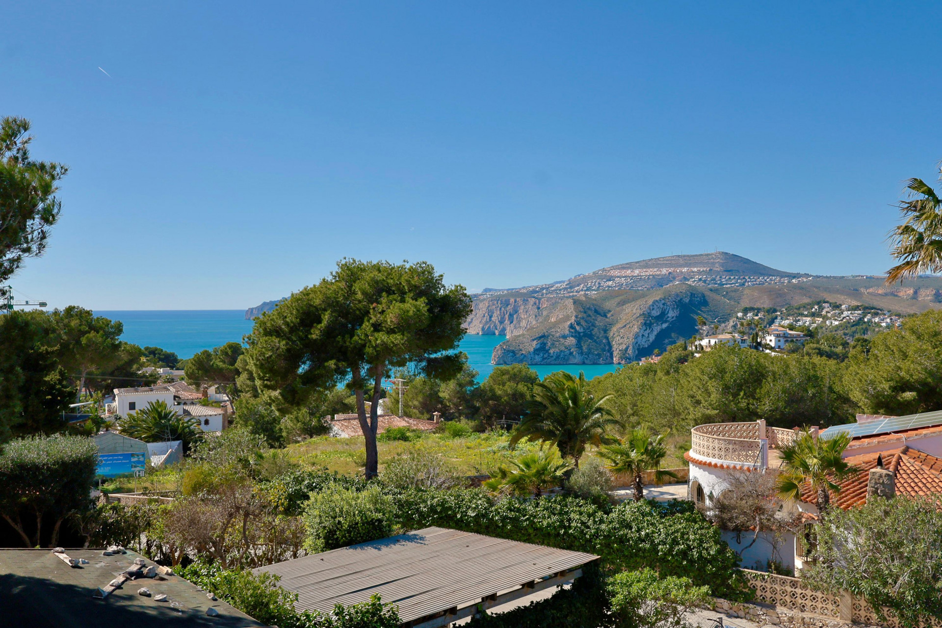 Vista panorámica de la costa y montaña de Jávea desde la terraza, con vegetación mediterránea.