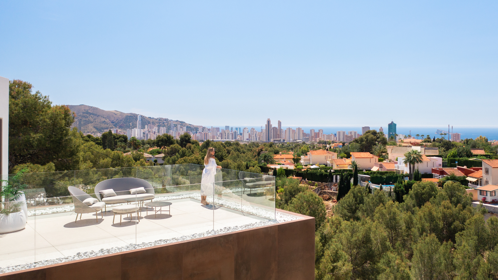 Terraza con vistas panorámicas de la ciudad y mobiliario moderno de exterior.