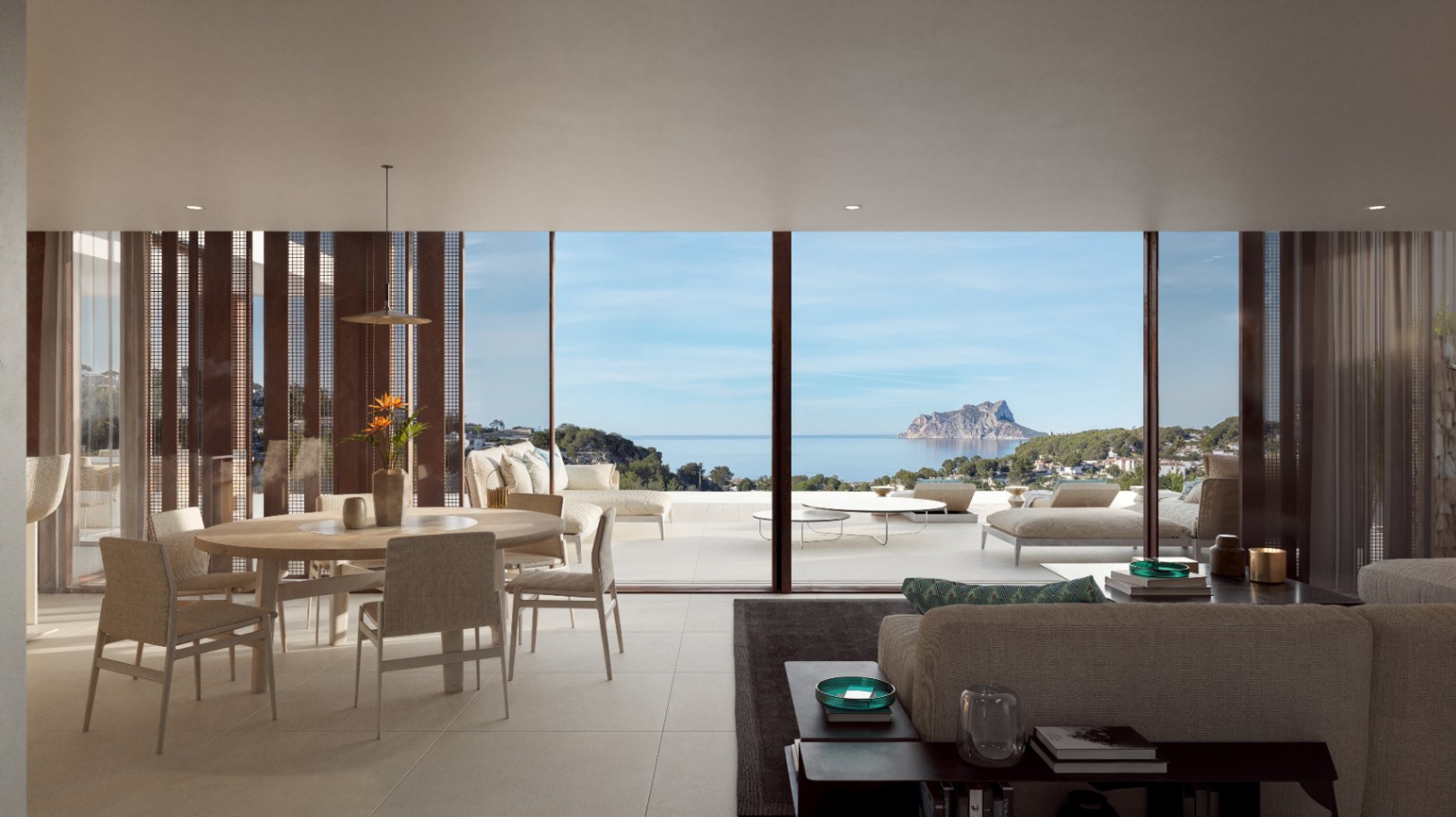 Salón-comedor diáfano con amplios ventanales que ofrecen vistas panorámicas al mar y al Peñón de Ifach, conectando el interior con la terraza principal.