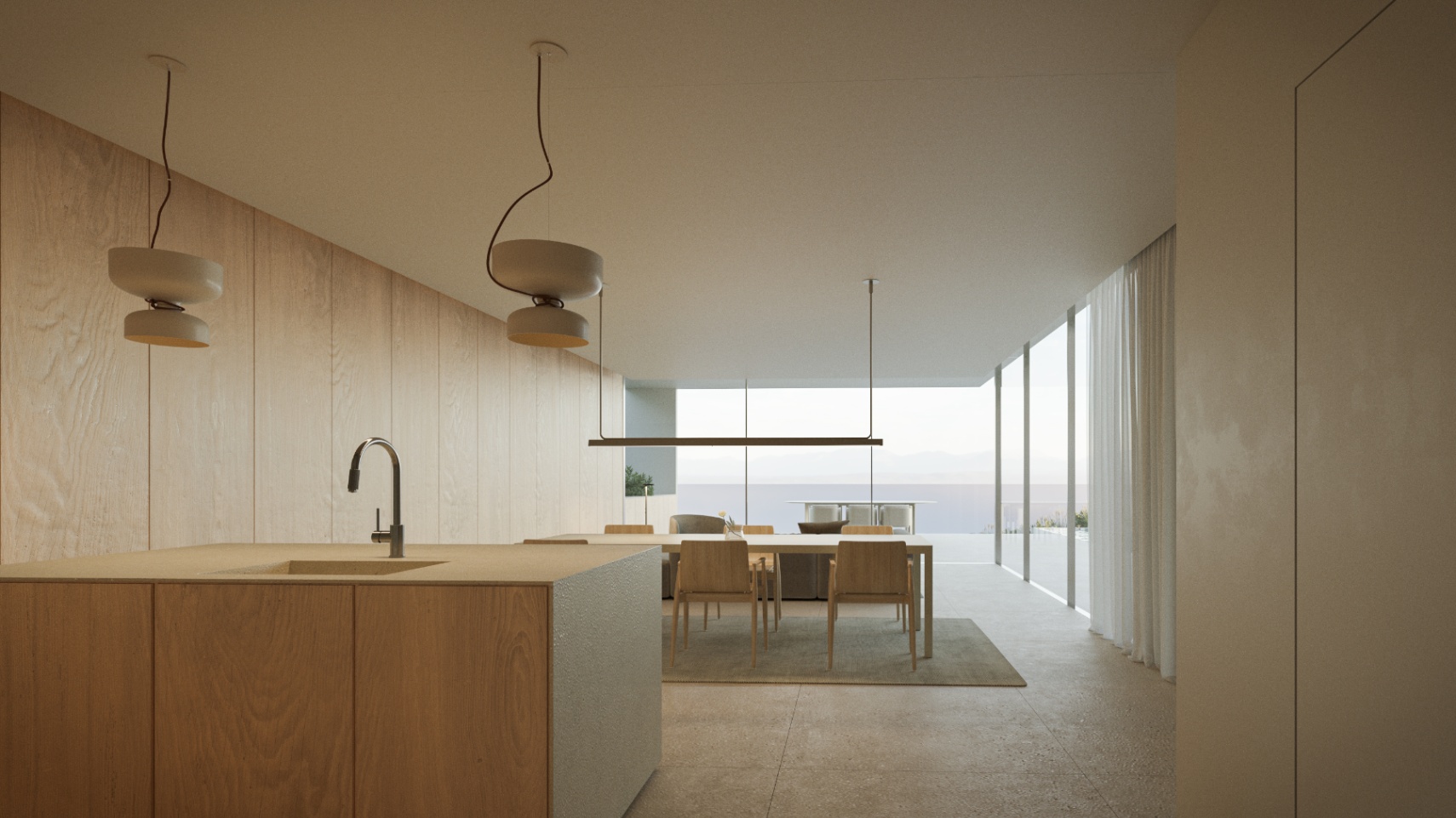 Cocina de diseño con isla de madera integrada en un espacio diáfano que incluye comedor y vistas panorámicas al mar a través de grandes ventanales.