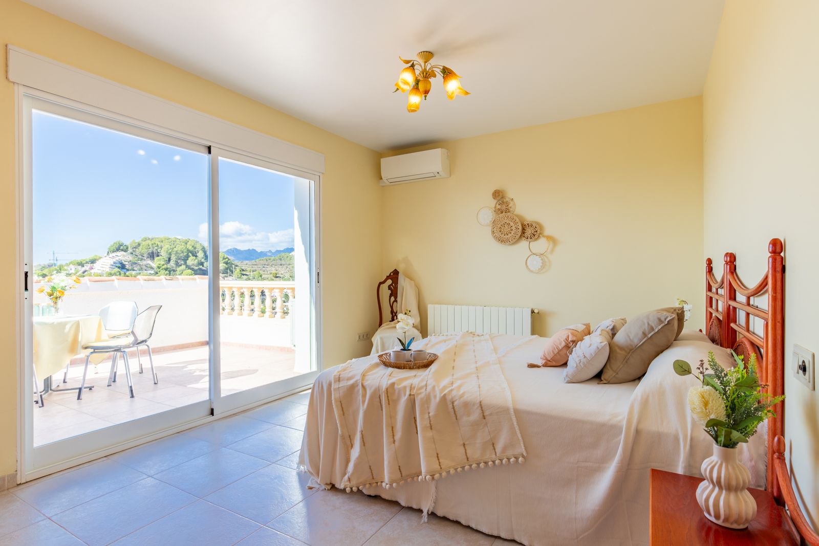 Dormitorio luminoso con acceso directo a una terraza privada. Incluye aire acondicionado, calefacción central y vistas despejadas a las montañas de Moraira.