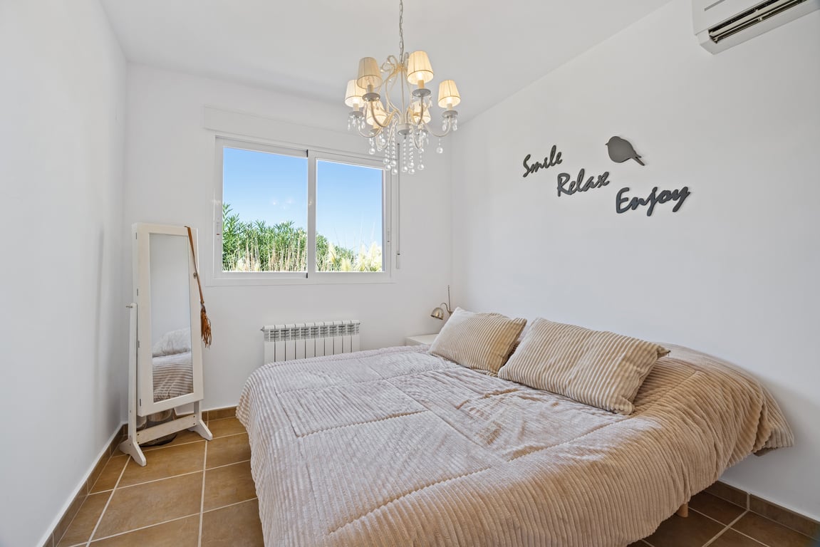 Dormitorio luminoso con suelos de gres, aire acondicionado split, calefacción central y ventana de doble acristalamiento con vistas al exterior.