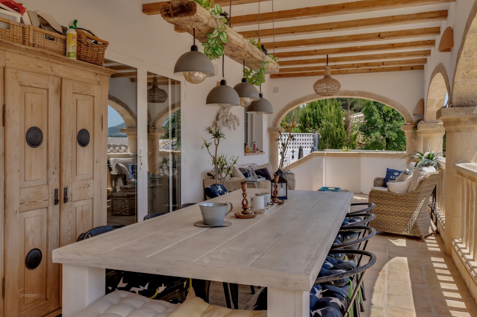 Terraza cubierta con mesa de comedor rústica y vistas al jardín.