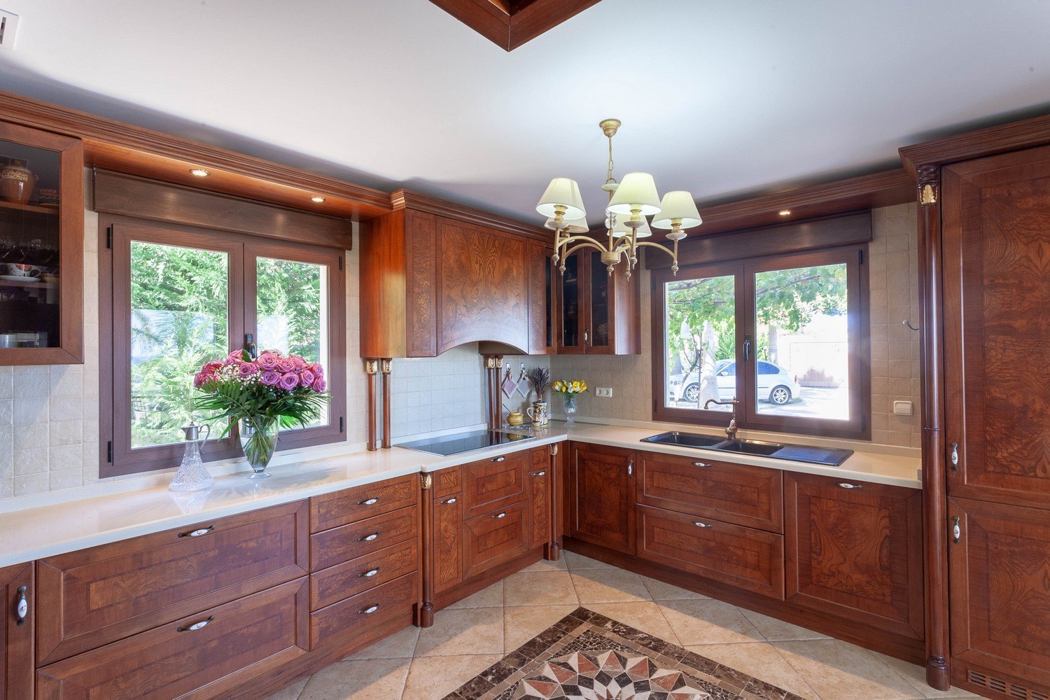 Cocina clásica con muebles de madera, encimera clara y suelo de baldosas con diseño geométrico.