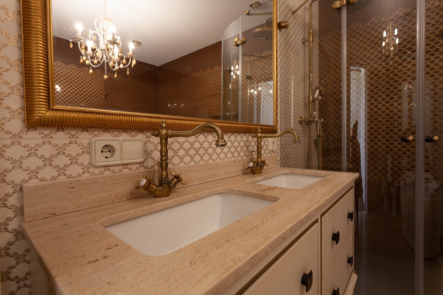 Detalle del baño con lavabo doble de mármol y grifería de latón.