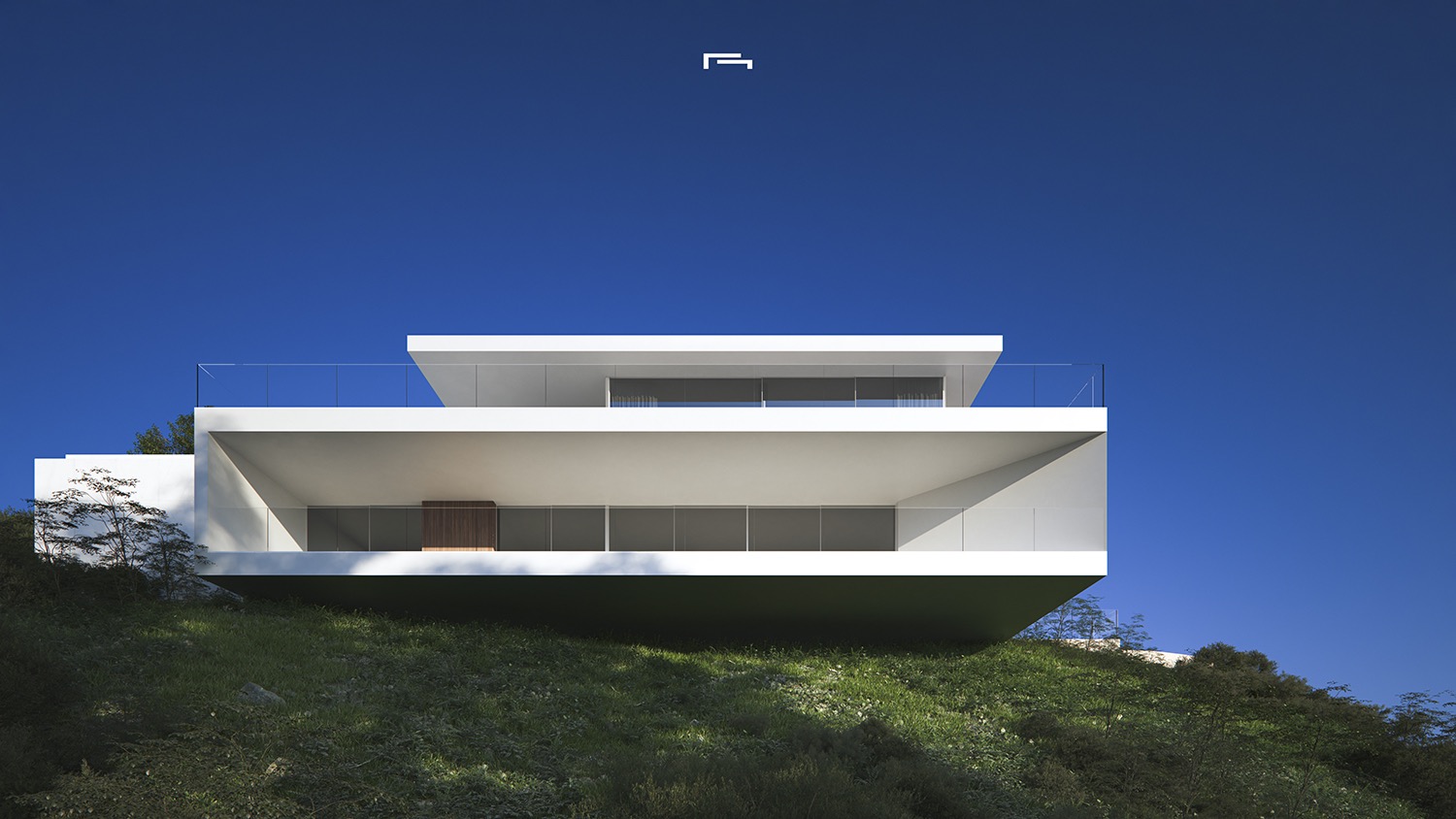Fachada exterior de arquitectura minimalista con voladizos blancos y amplias cristaleras, integrada en una ladera natural bajo un cielo despejado.