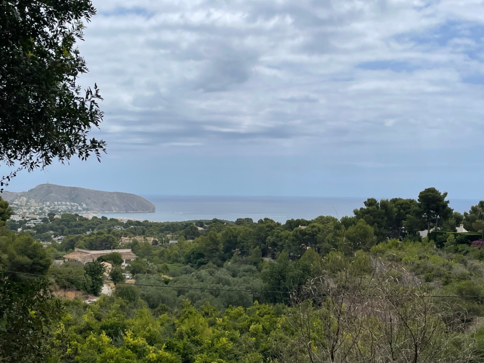 Vista panorámica desde la parcela hacia el mar Mediterráneo y el Cap d'Or, rodeada de vegetación autóctona y pinos en la zona de Benimeit, Moraira.