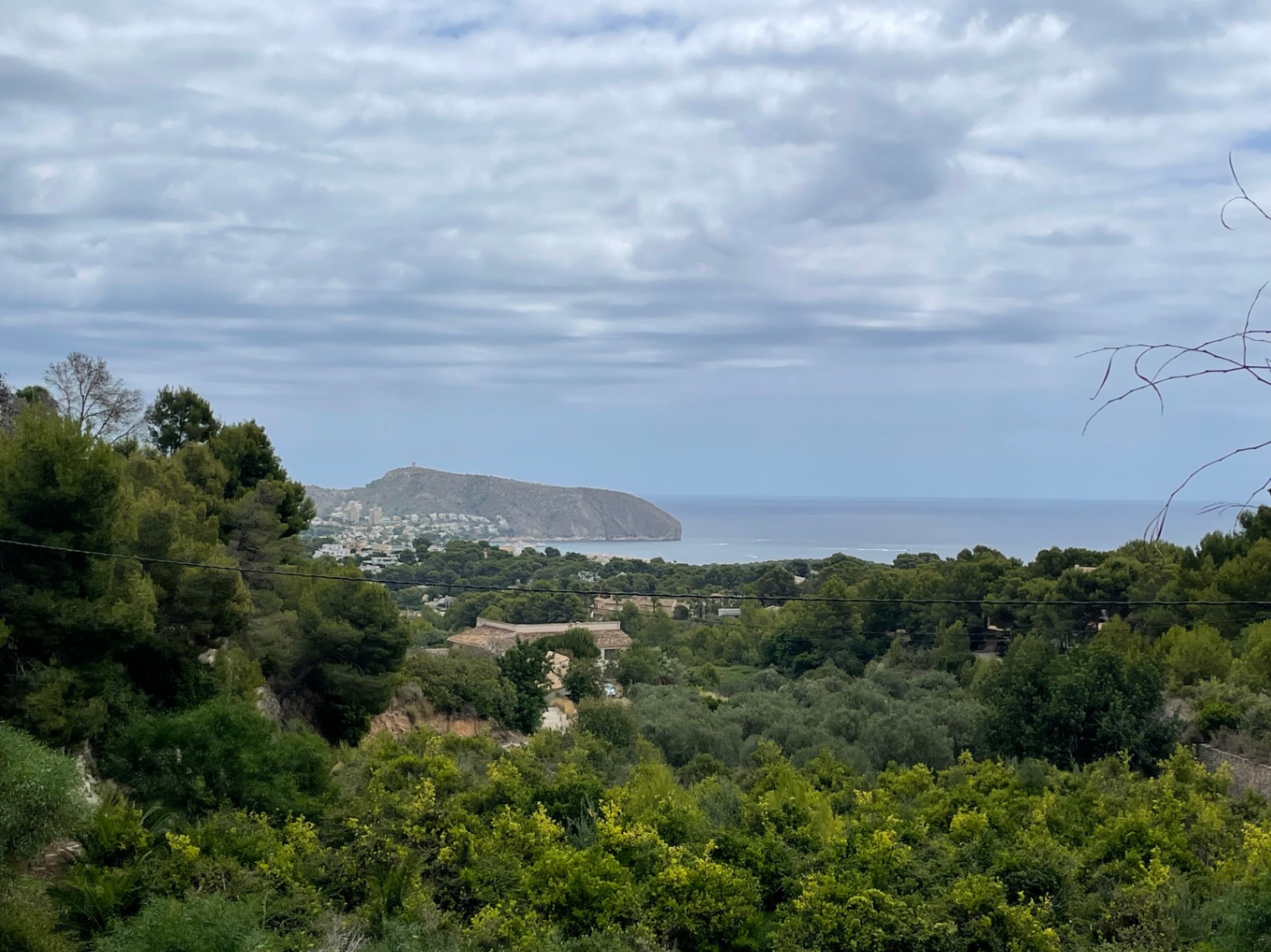 Vistas panorámicas al mar Mediterráneo y al Cap d'Or desde la parcela elevada en Benimeit, rodeada de vegetación autóctona y pinos.