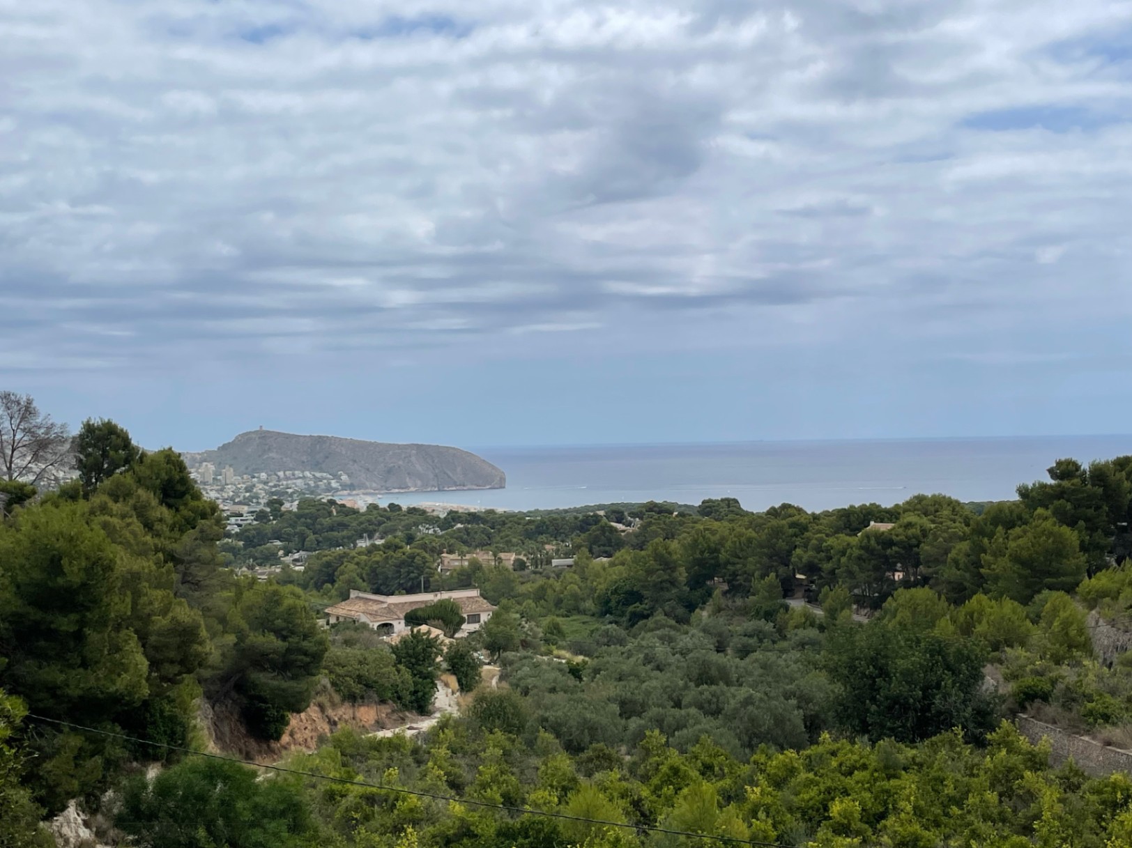 Vistas panorámicas al mar Mediterráneo y al Cap d'Or desde la zona elevada de Benimeit, rodeada de frondosa vegetación autóctona y pinos.