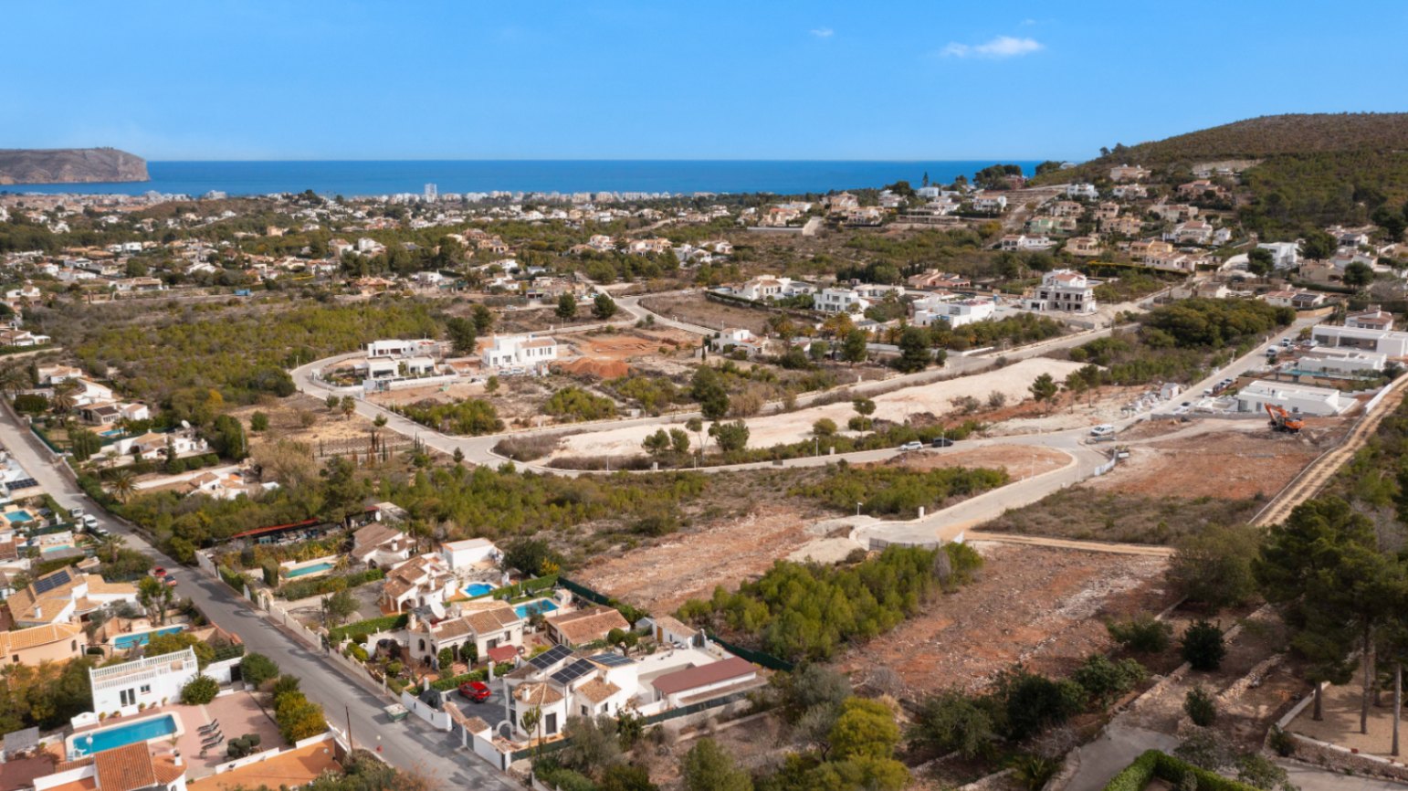 Vista aérea de Jávea con parcelas y villas blancas bajo el sol, Costa Blanca.