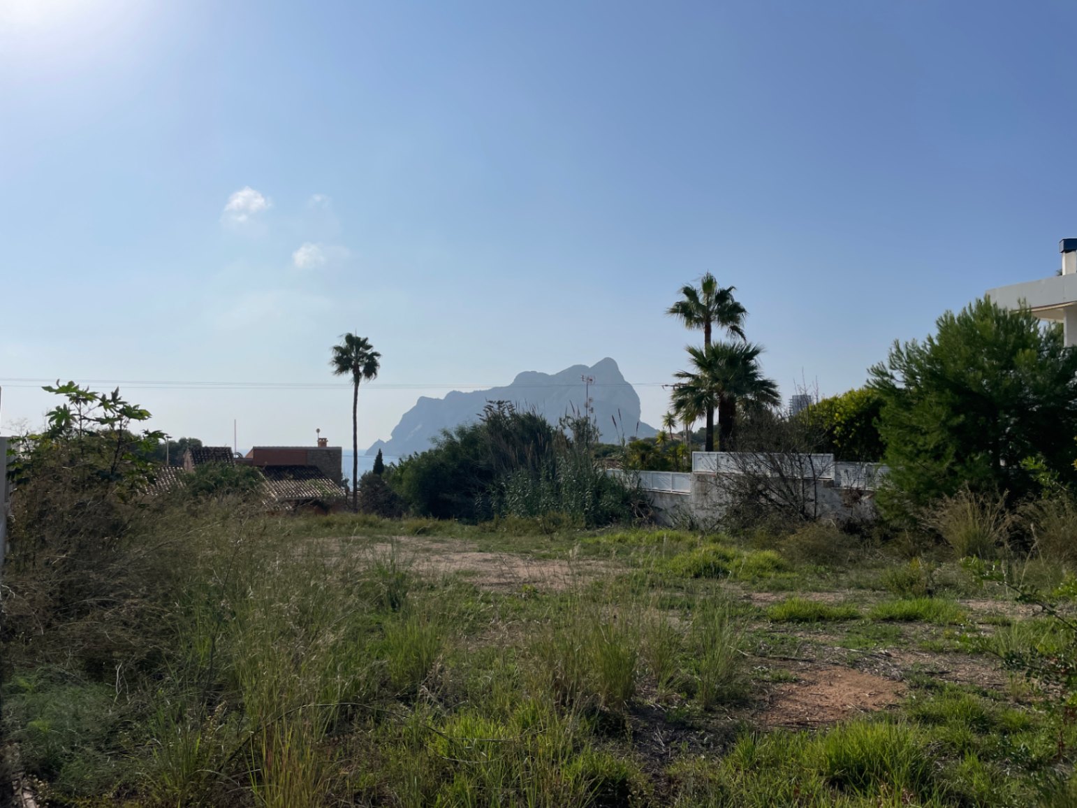 Parcela llana con vegetación natural y vistas despejadas al Peñón de Ifach bajo un cielo mediterráneo en Bassetes, Calpe.