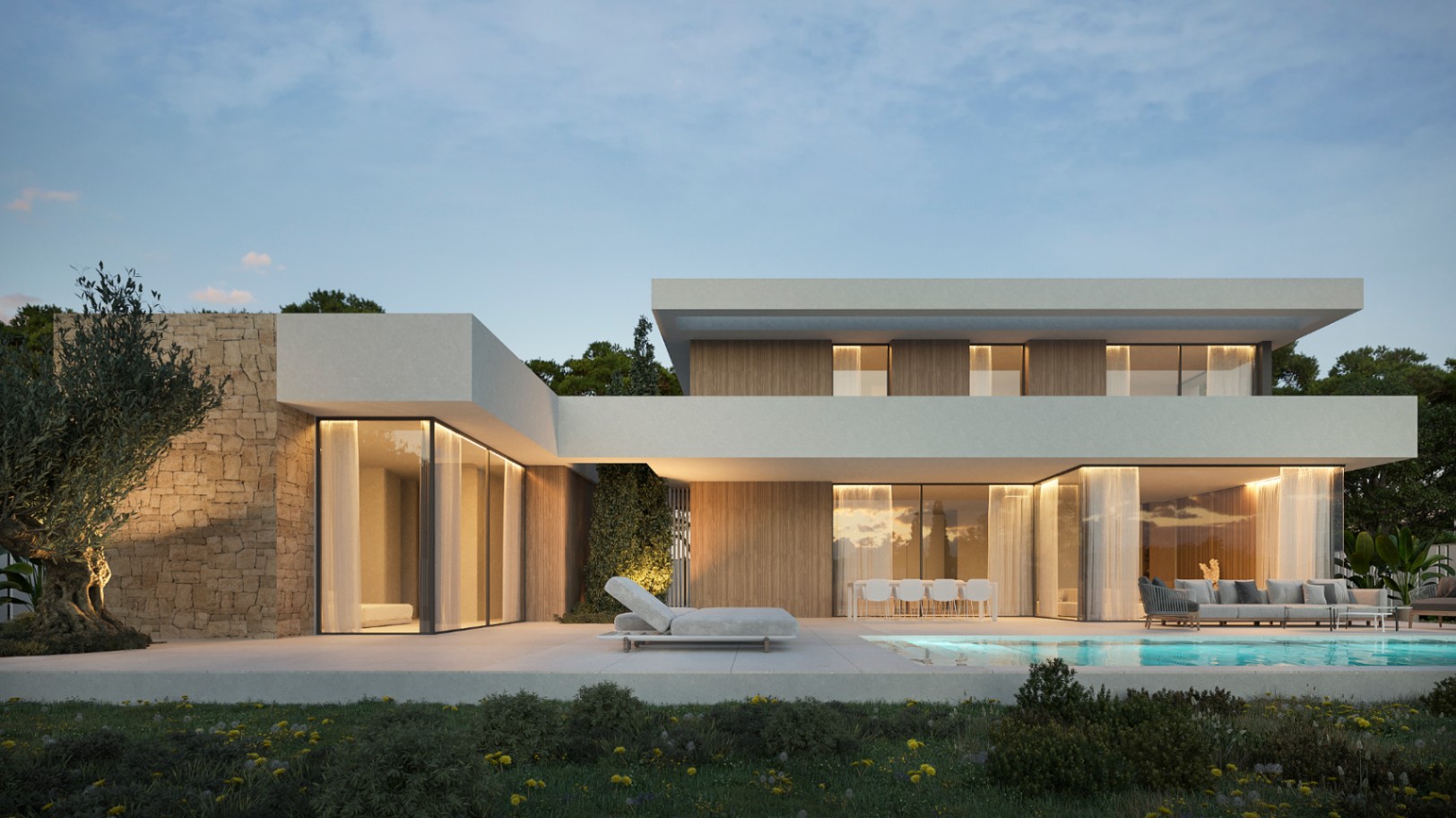 Fachada de diseño ibicenco con muros de piedra, grandes ventanales, piscina integrada y zonas de estar exteriores bajo una iluminación cálida al atardecer.