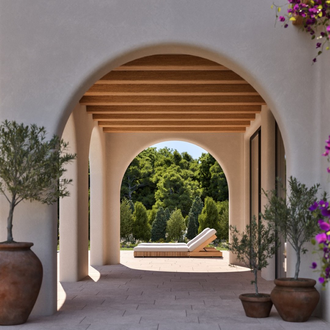 Naya de estilo mediterráneo con arcos de medio punto, techos de vigas de madera y suelos de piedra natural que se abren a un jardín privado con tumbonas.