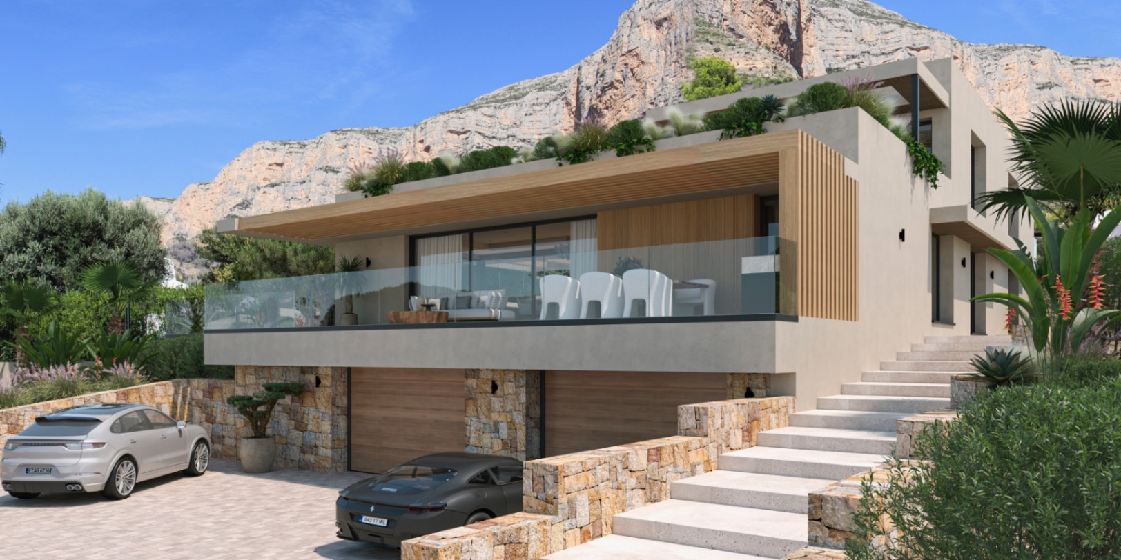 Fachada moderna con muros de piedra natural, garaje doble y amplia terraza con barandillas de cristal bajo el imponente macizo del Montgó.