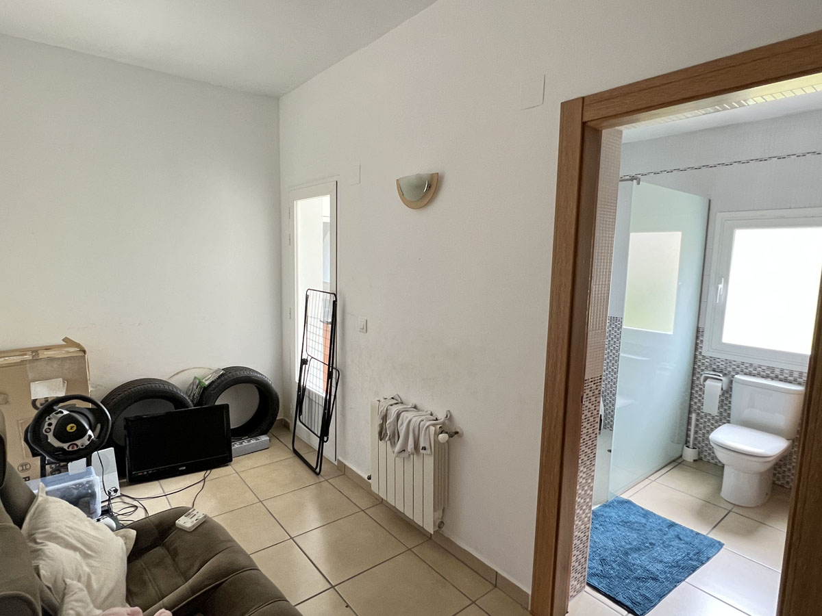 Habitación de invitados con baño privado, suelos de gres y calefacción central. El baño integrado dispone de ducha con mampara de cristal y ventana exterior.