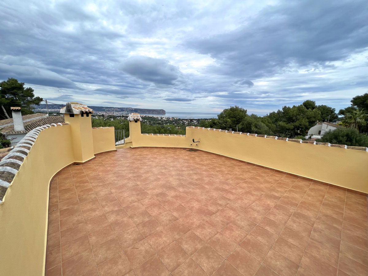 Terraza solárium con suelo de gres cerámico y muro perimetral curvo, ofreciendo vistas panorámicas al mar Mediterráneo y al Cabo San Antonio en Jávea.
