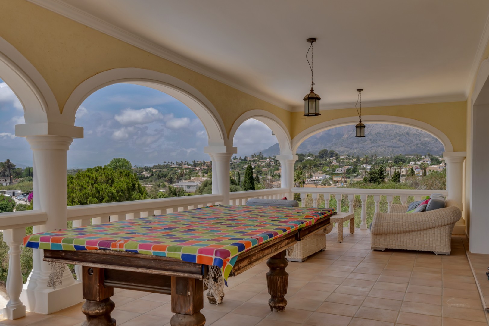 Naya cubierta con arcos tradicionales, mesa de billar y zona de estar, ofreciendo vistas panorámicas al valle de Jávea y al monte Montgó.