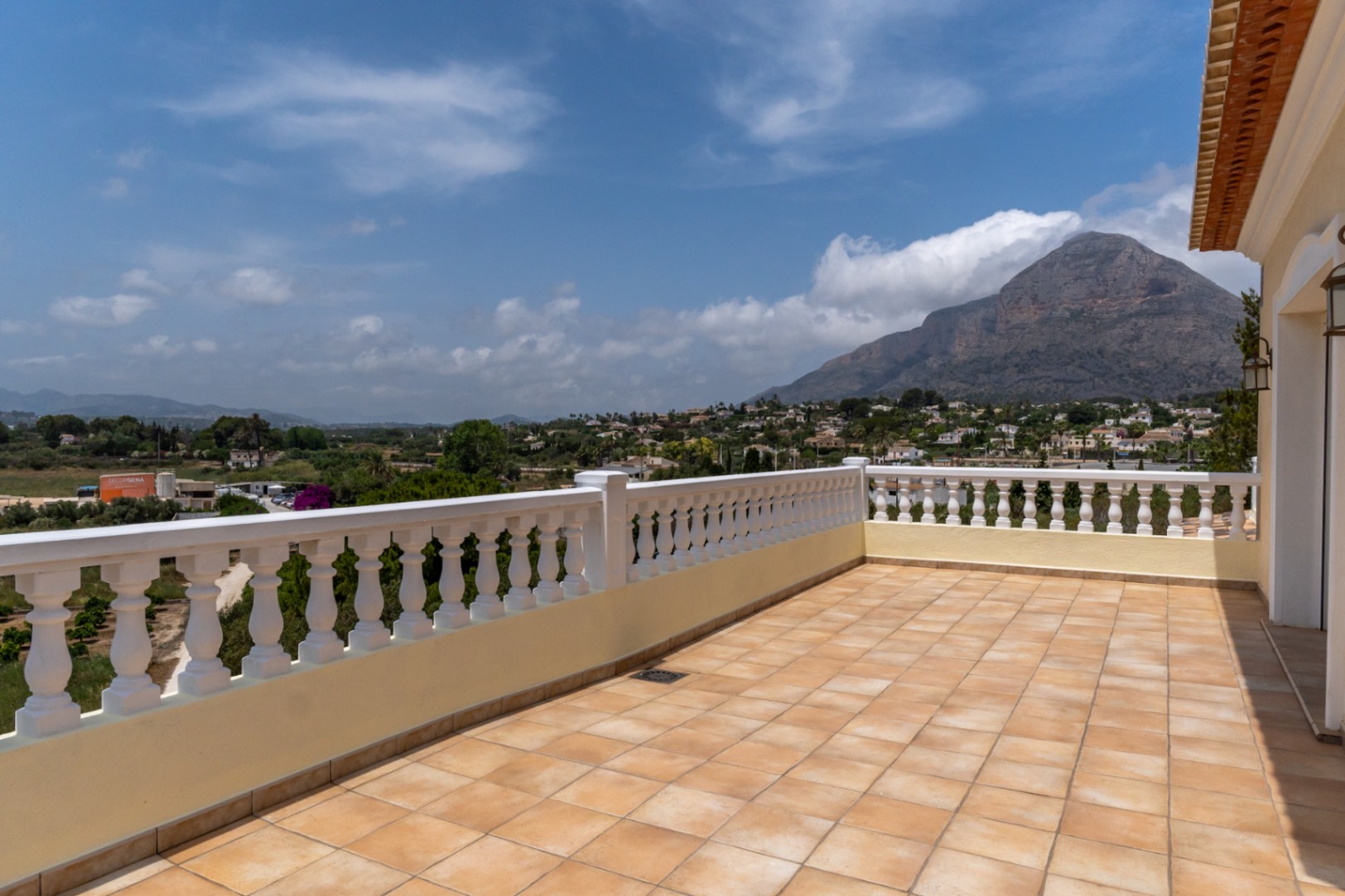 Terraza superior con suelo de baldosas cerámicas y balaustrada blanca, ofreciendo vistas panorámicas despejadas al Montgó y al valle de Jávea.