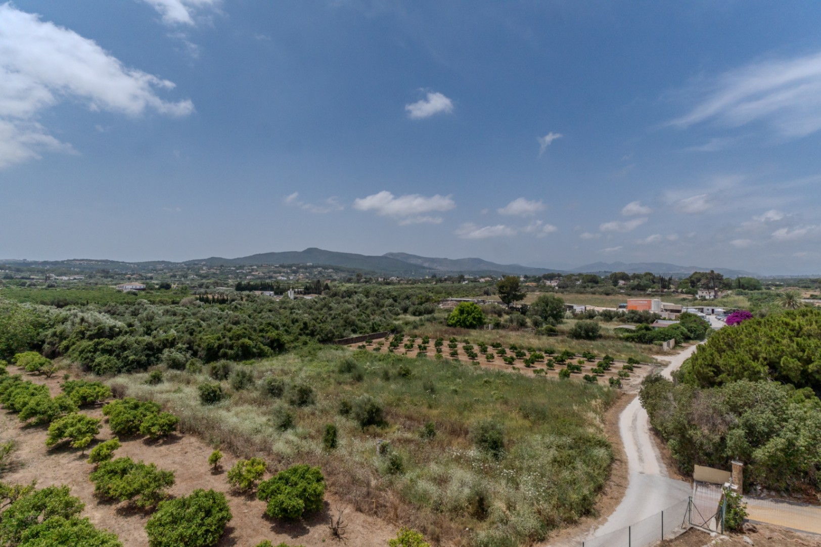Vistas panorámicas de 180º sobre el valle de Jávea, con huertos de cítricos y vegetación autóctona que se extienden hacia las colinas de Benitachell.