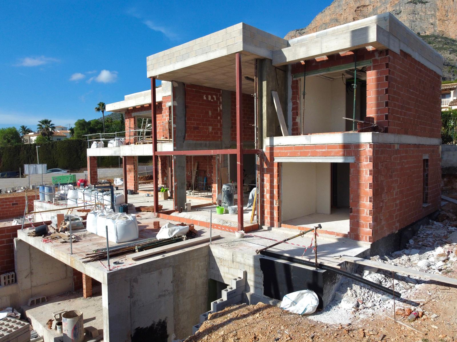 Estado actual de la construcción de la villa, mostrando la estructura de ladrillo, forjados de hormigón y vigas de acero con el Montgó al fondo.