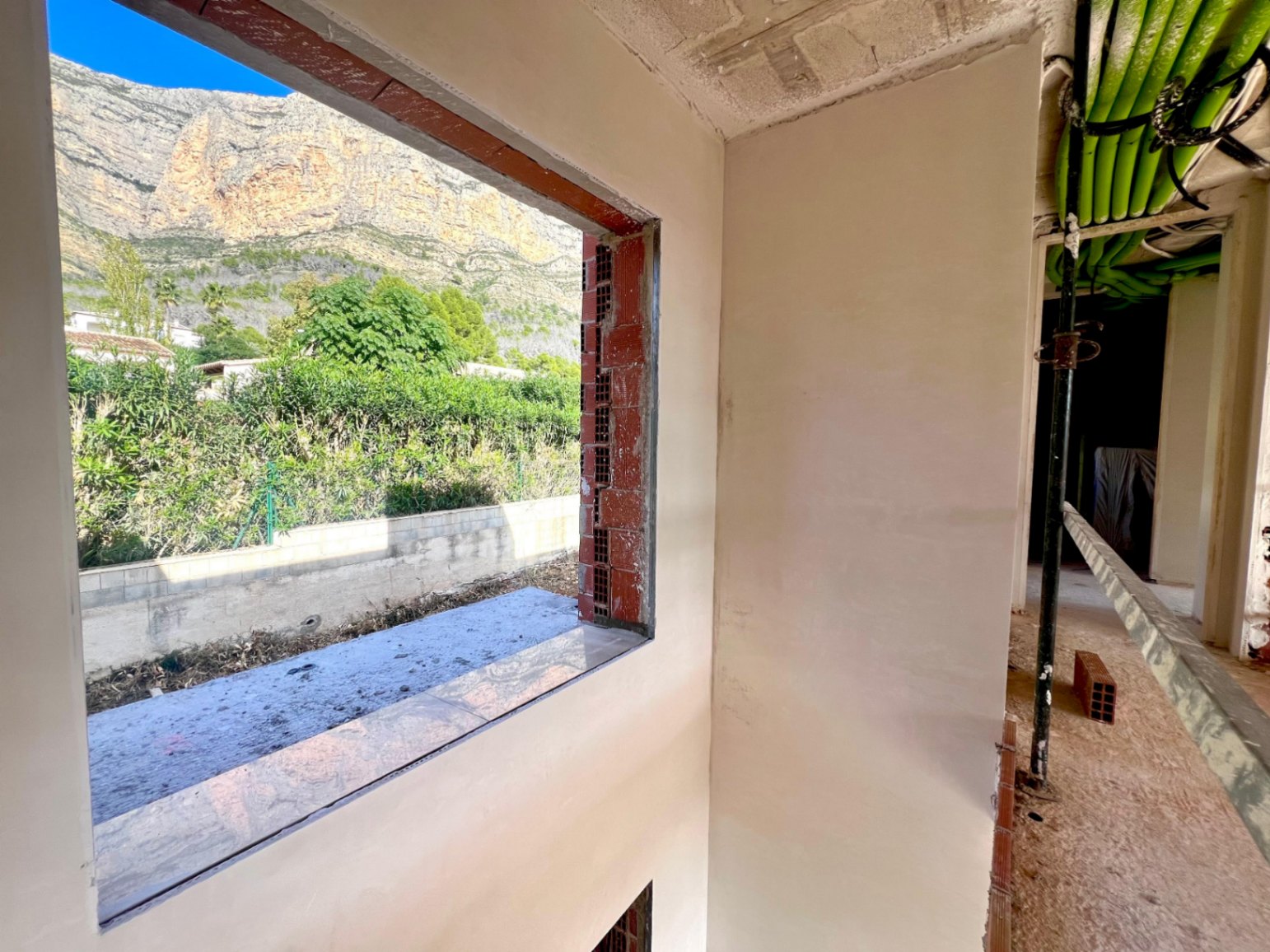 Vista del macizo del Montgó desde el interior en construcción, mostrando la integración de las instalaciones y los amplios ventanales proyectados.