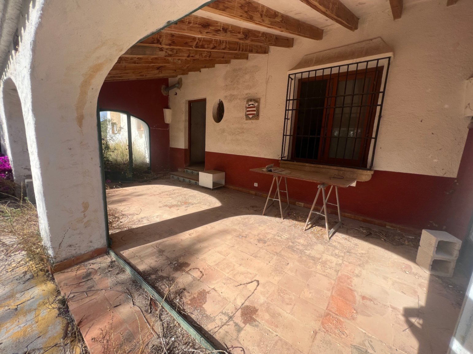 Naya tradicional con vigas de madera a la vista, suelos de barro cocido y arcos mediterráneos que dan acceso al jardín y al interior de la vivienda.