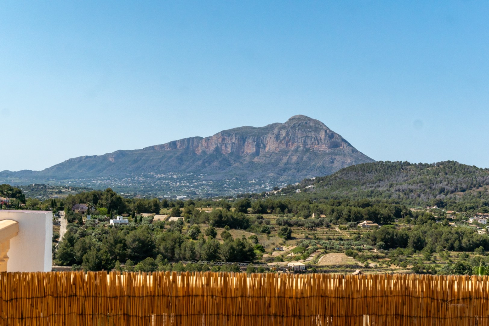 Vistas panorámicas frontales al macizo del Montgó desde la terraza, con un entorno natural de pinos y vegetación mediterránea bajo un cielo despejado.