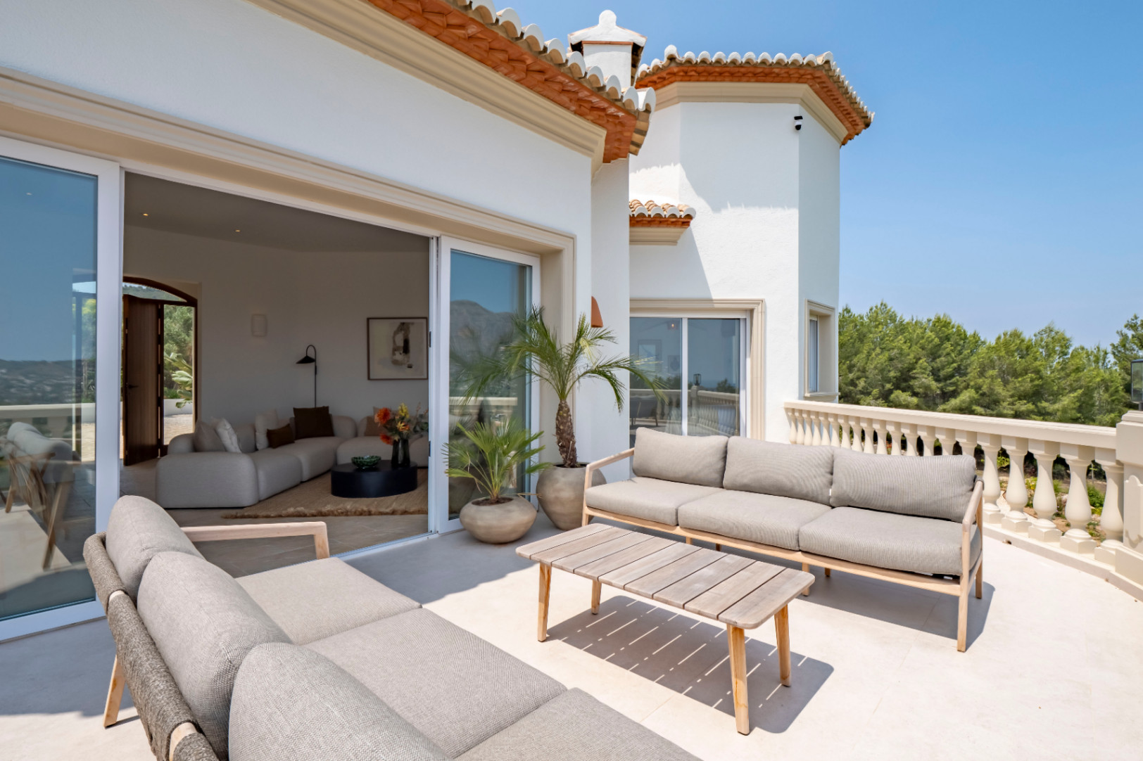 Terraza con vistas en Jávea. Mobiliario de exterior en tonos neutros y acceso al salón.