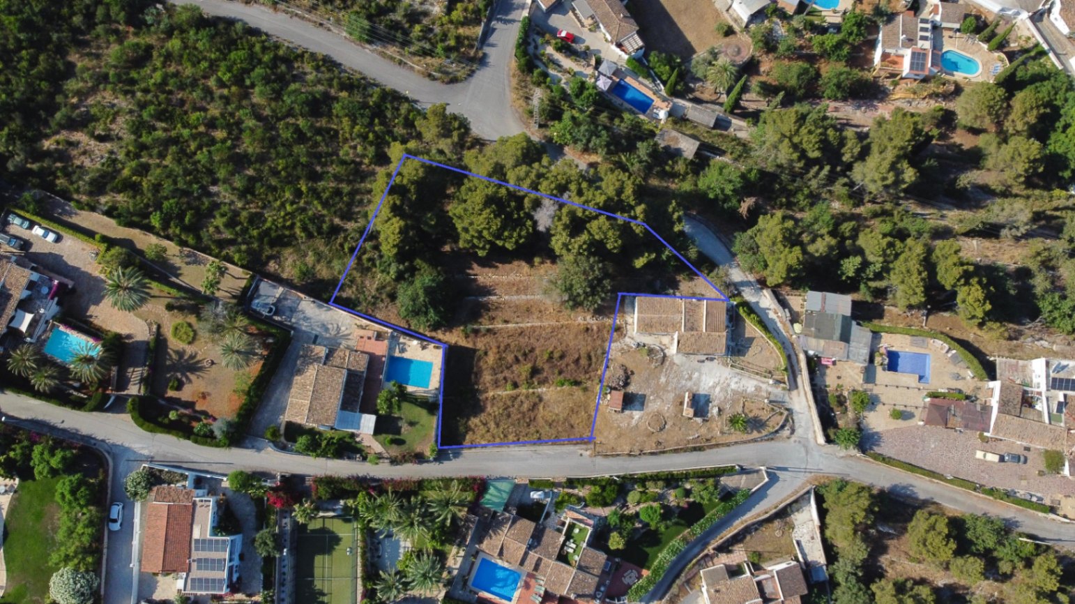 Vista aérea perimetrada de la parcela de 1.908 m² en Jávea, mostrando su orografía aterrazada, vegetación mediterránea y ubicación en una zona residencial consolidada.