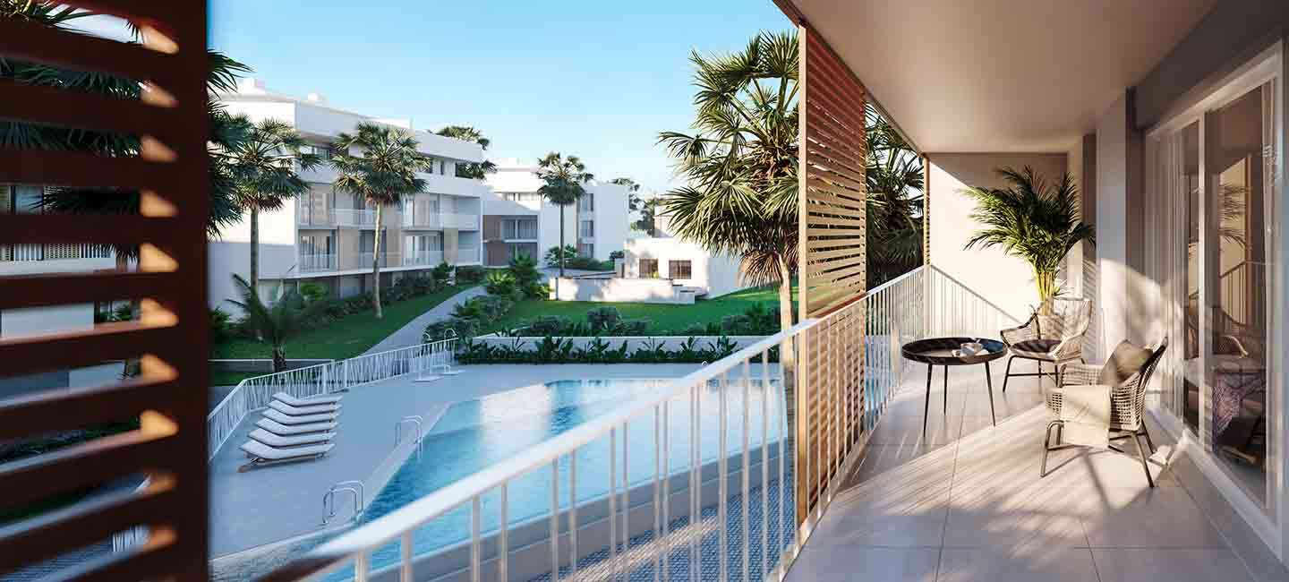 Terraza privada con suelo cerámico y mobiliario moderno, con vistas directas a la piscina comunitaria y los jardines con palmeras.