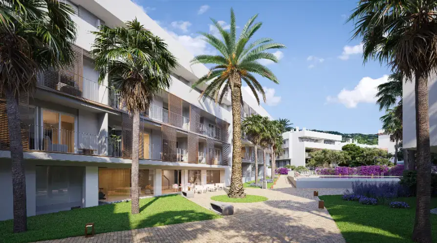 Exterior de apartamentos modernos con jardines paisajísticos, palmeras, caminos pavimentados y una piscina comunitaria frente a una fachada blanca con celosías de madera.