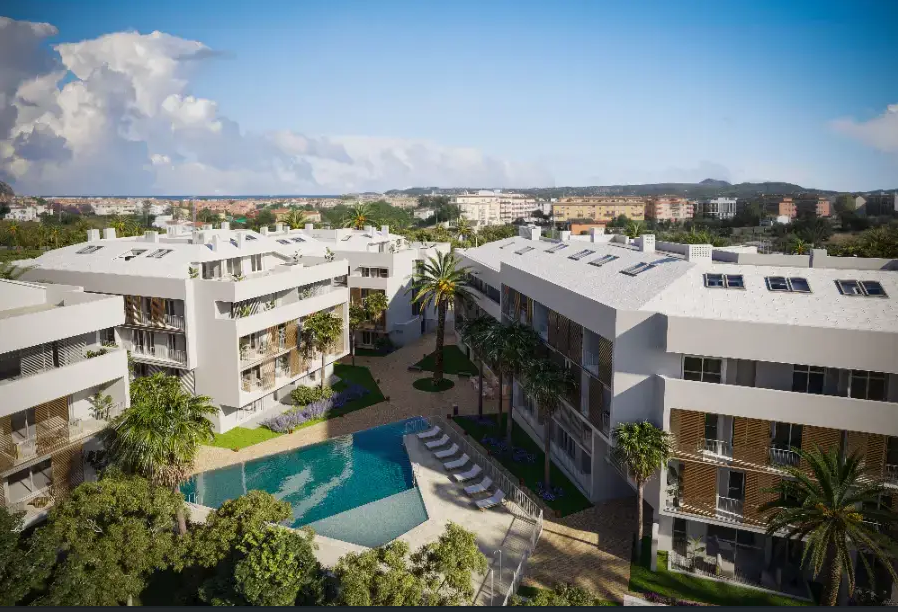 Vista elevada del complejo residencial con piscina geométrica, jardines mediterráneos con palmeras y edificios blancos de diseño contemporáneo.