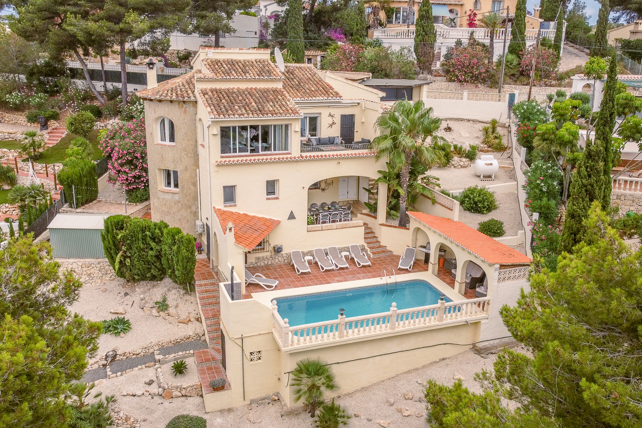 Vista elevada de la villa orientada al sur con piscina de 8x4m, terraza de terracota y varias nayas cubiertas integradas en la arquitectura mediterránea escalonada.